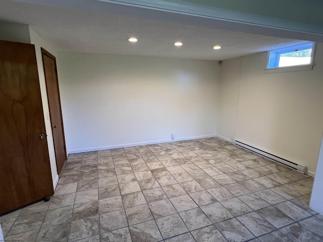 below grade area with baseboard heating, baseboards, stone finish floor, and recessed lighting