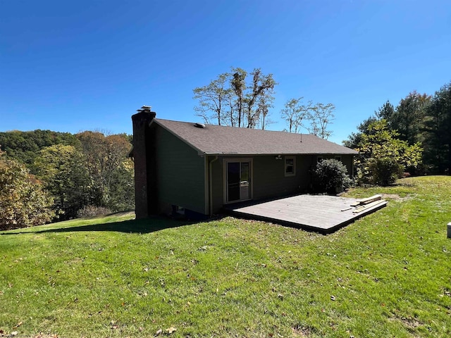 back of property with a wooden deck and a lawn