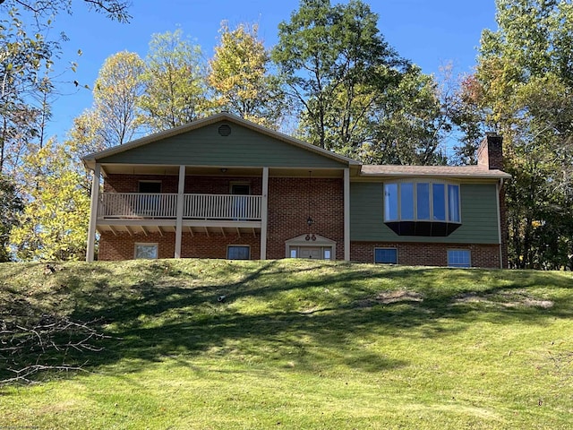 view of front of home with brick siding, a chimney, and a front lawn