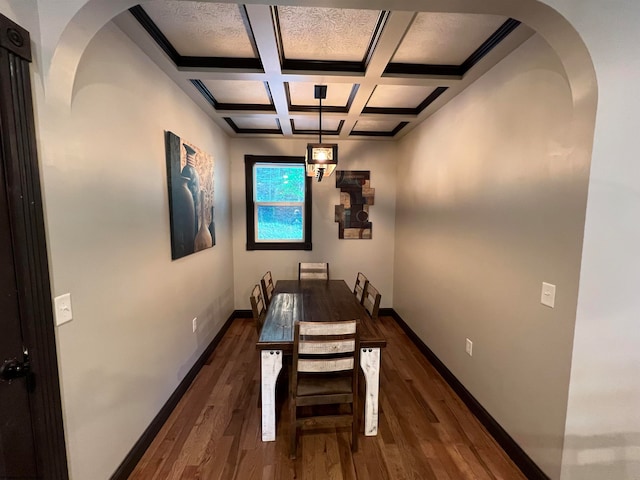 dining room with coffered ceiling, dark hardwood / wood-style flooring, and beam ceiling