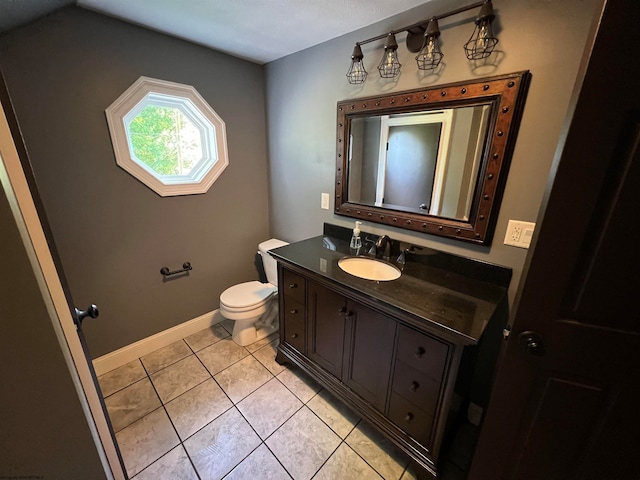 bathroom with tile patterned flooring, vanity, and toilet