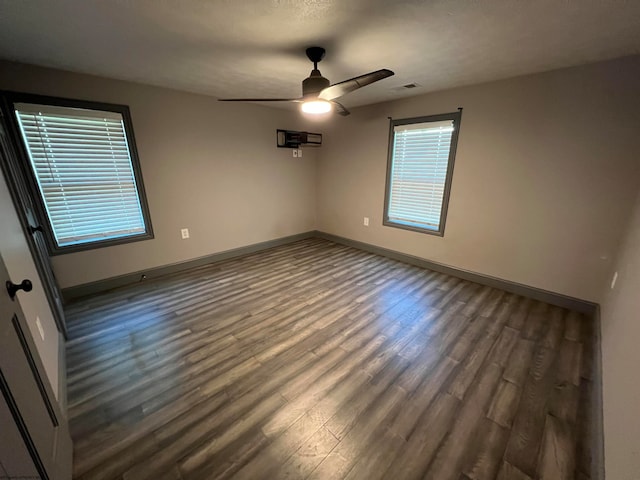 empty room with ceiling fan and dark wood-type flooring