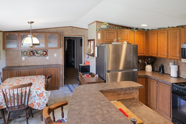 kitchen with lofted ceiling, pendant lighting, light tile patterned flooring, and appliances with stainless steel finishes