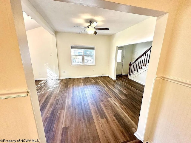 unfurnished living room featuring ceiling fan and dark hardwood / wood-style floors