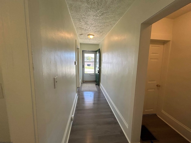 hallway featuring dark hardwood / wood-style floors and a textured ceiling