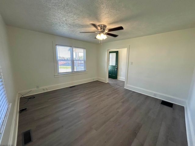 spare room featuring a textured ceiling, ceiling fan, and dark hardwood / wood-style flooring