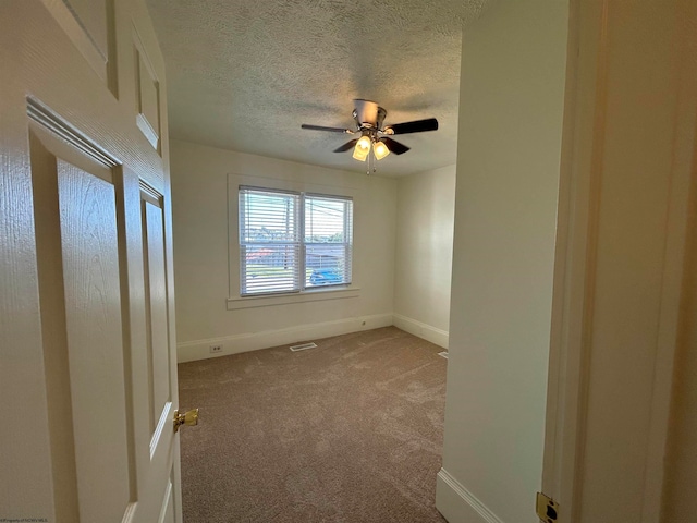 carpeted empty room with a textured ceiling and ceiling fan