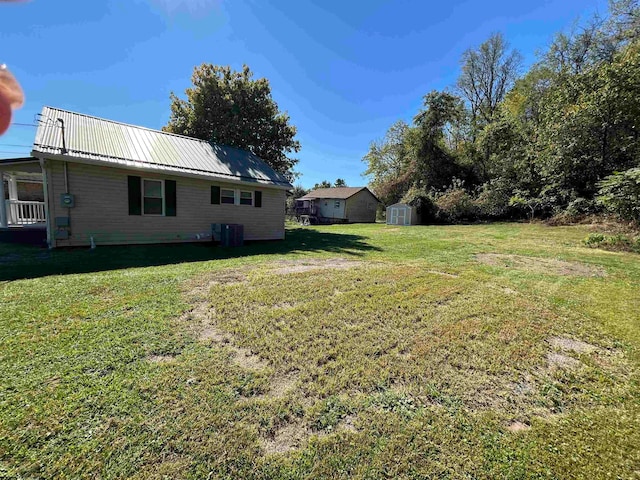 view of yard featuring central AC and a shed