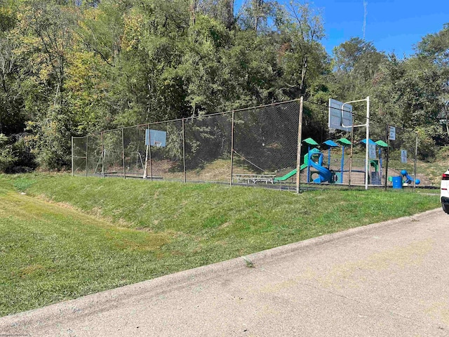 exterior space featuring basketball hoop and a yard