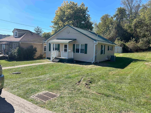 view of front of property with a front yard and central AC