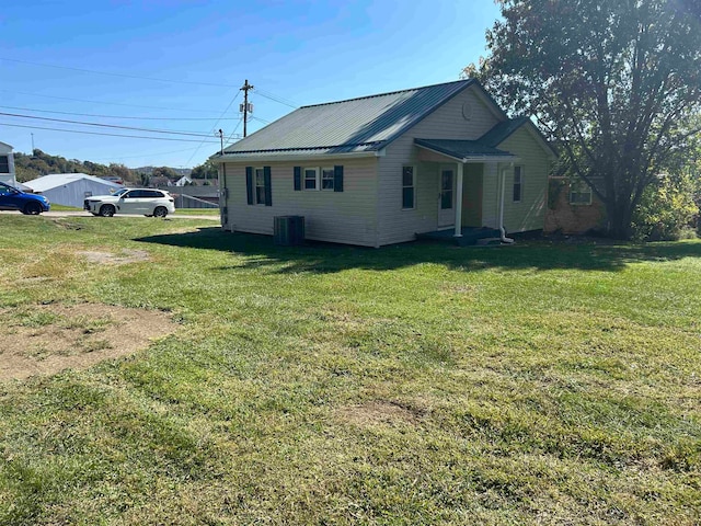 view of property exterior with central air condition unit and a yard