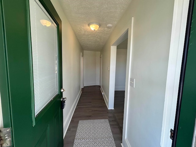 corridor with dark hardwood / wood-style floors and a textured ceiling