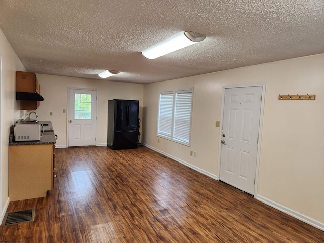 interior space featuring dark hardwood / wood-style floors and a textured ceiling