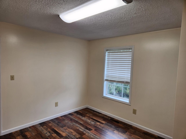 unfurnished room with a textured ceiling and dark hardwood / wood-style flooring