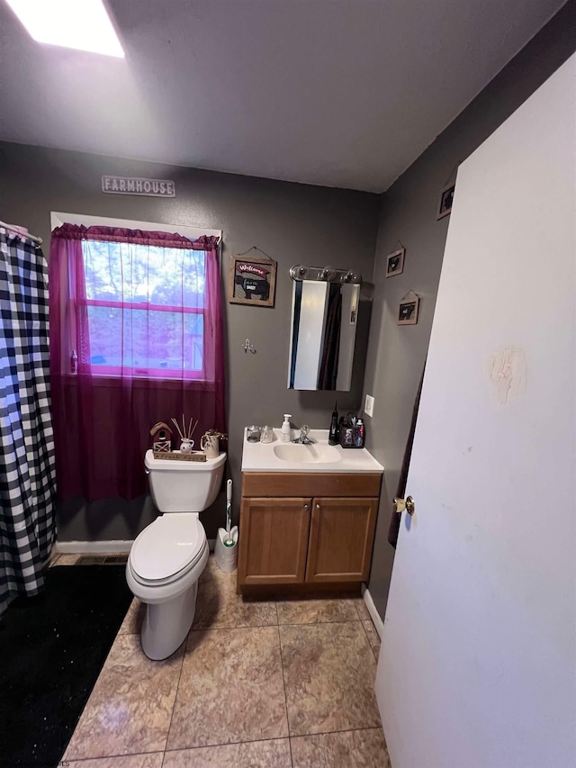 bathroom with vanity, tile patterned flooring, toilet, and walk in shower