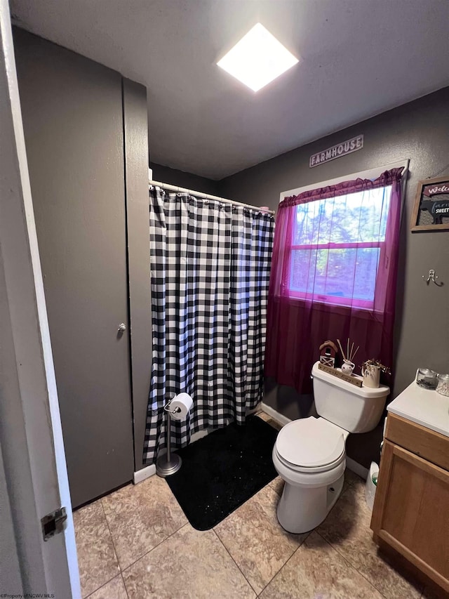 bathroom with a shower with curtain, tile patterned flooring, vanity, and toilet