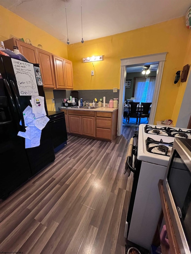 kitchen with dark wood-type flooring, black appliances, sink, and ceiling fan