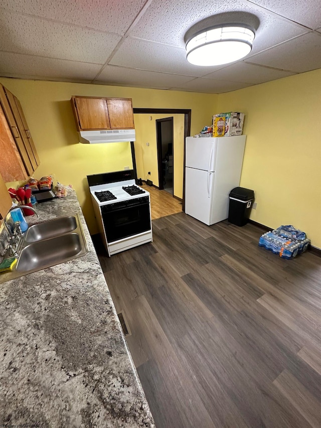 kitchen with a paneled ceiling, white appliances, dark hardwood / wood-style floors, and sink