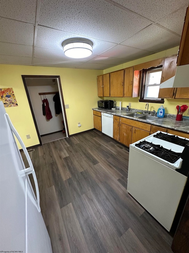 kitchen with dark wood-type flooring, a paneled ceiling, white appliances, and sink