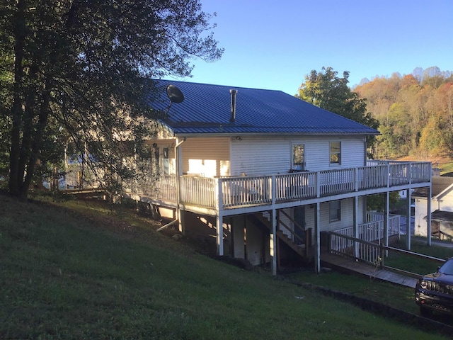 rear view of property with a lawn and a wooden deck