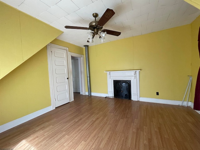 unfurnished living room featuring ceiling fan and hardwood / wood-style floors