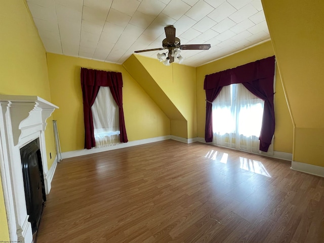 bonus room with hardwood / wood-style floors and ceiling fan