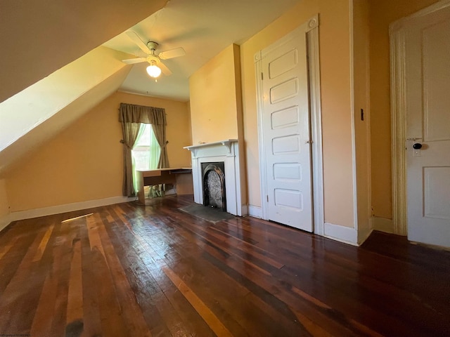 unfurnished living room featuring ceiling fan, vaulted ceiling, and dark wood-type flooring