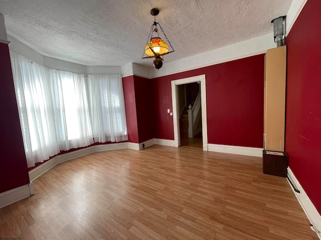 empty room with wood-type flooring and a textured ceiling