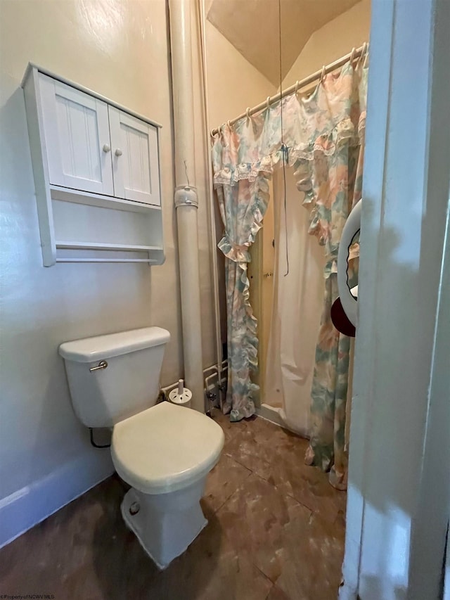 bathroom with lofted ceiling and toilet