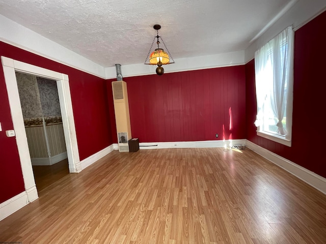 unfurnished dining area featuring hardwood / wood-style flooring and a textured ceiling