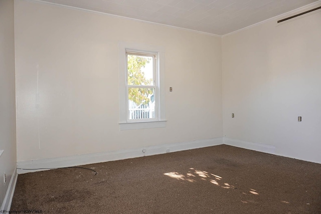 empty room featuring ornamental molding and carpet