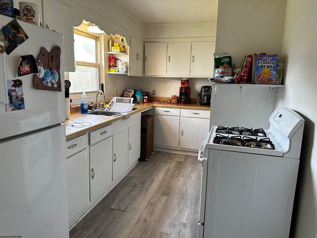 kitchen featuring light wood-type flooring, white appliances, white cabinetry, and sink