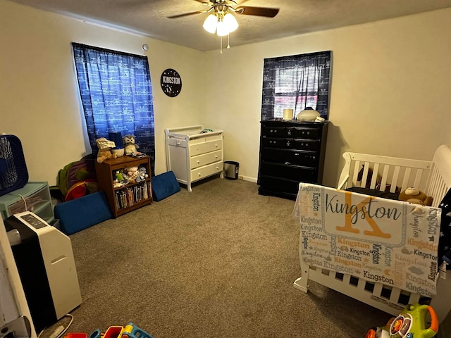 carpeted bedroom featuring ceiling fan, a nursery area, and a textured ceiling