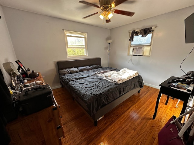 bedroom featuring multiple windows, ceiling fan, cooling unit, and dark hardwood / wood-style floors