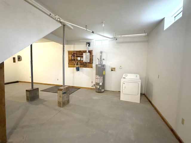 basement with water heater, a healthy amount of sunlight, and washer / dryer