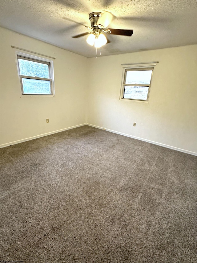 carpeted spare room with ceiling fan and a textured ceiling