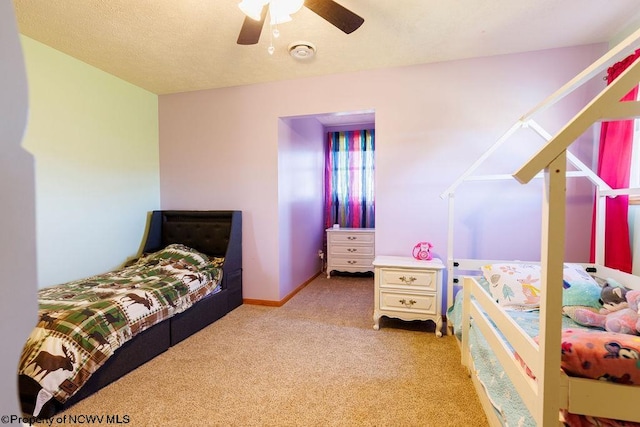 bedroom featuring a textured ceiling, ceiling fan, and light carpet