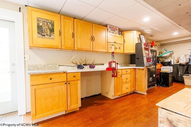 kitchen featuring wood-type flooring and a drop ceiling