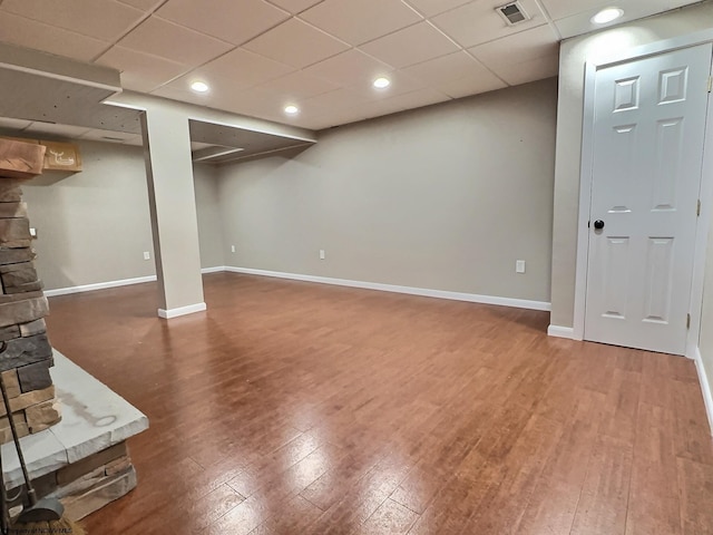 basement with a drop ceiling and wood-type flooring