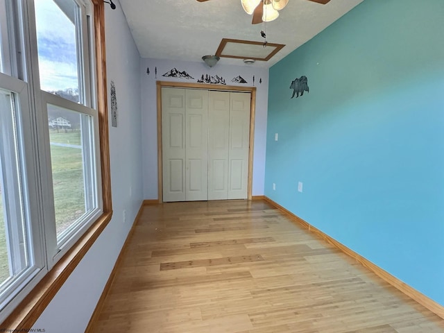 unfurnished bedroom with ceiling fan, a closet, and light hardwood / wood-style floors