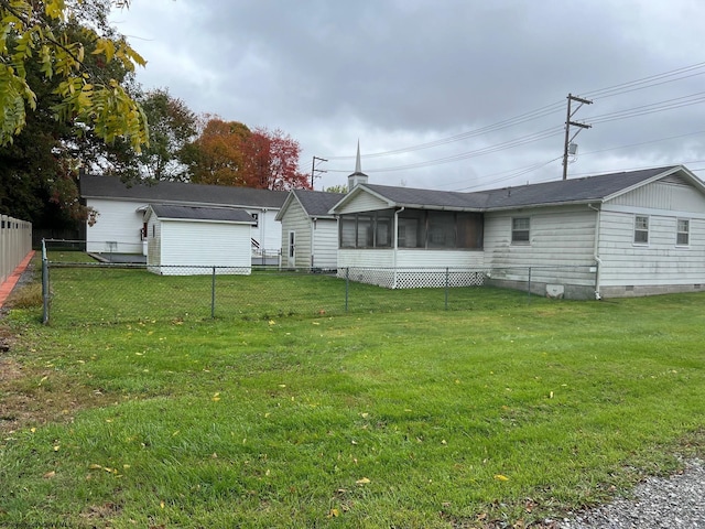 back of house featuring a sunroom and a lawn