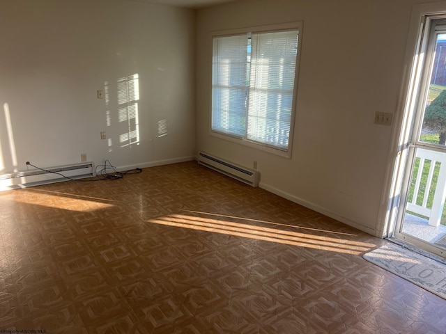 spare room with a baseboard heating unit and a wealth of natural light