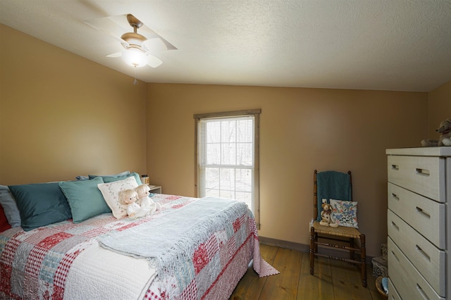 bedroom featuring ceiling fan, hardwood / wood-style flooring, vaulted ceiling, and a textured ceiling