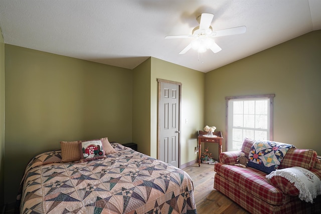 bedroom featuring ceiling fan, hardwood / wood-style flooring, and vaulted ceiling