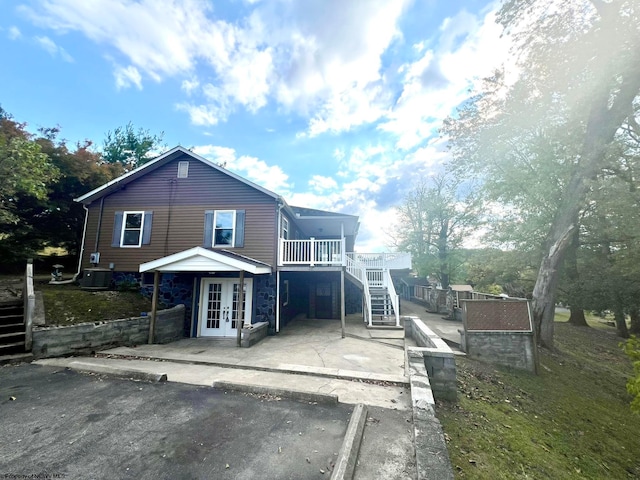 rear view of property with a deck and french doors