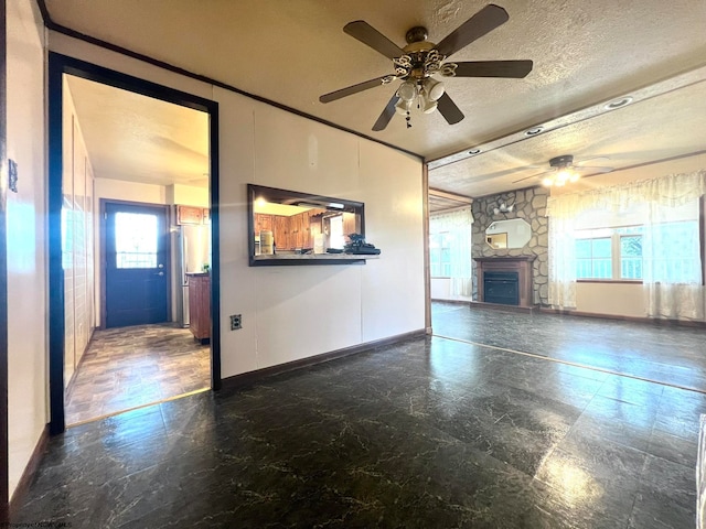 unfurnished living room featuring ceiling fan, a textured ceiling, and a fireplace