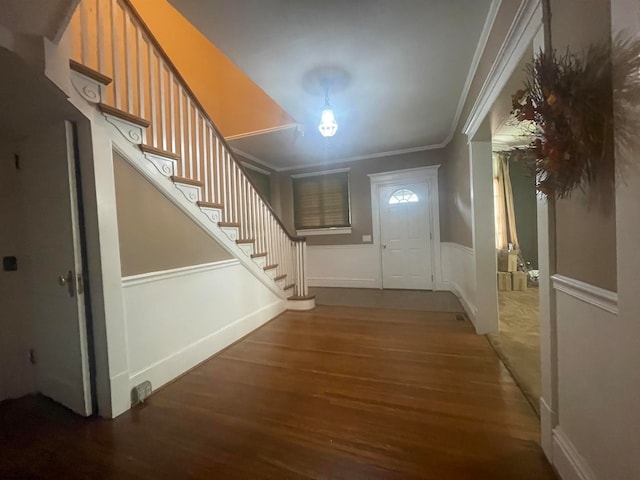 foyer entrance with ornamental molding and wood-type flooring