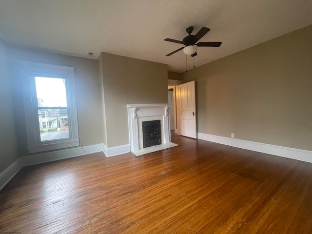 unfurnished living room with dark hardwood / wood-style floors and ceiling fan