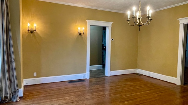 spare room featuring ornamental molding, a notable chandelier, dark hardwood / wood-style floors, and a textured ceiling