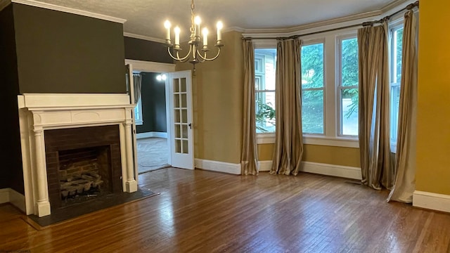 unfurnished living room with ornamental molding, dark wood-type flooring, and an inviting chandelier